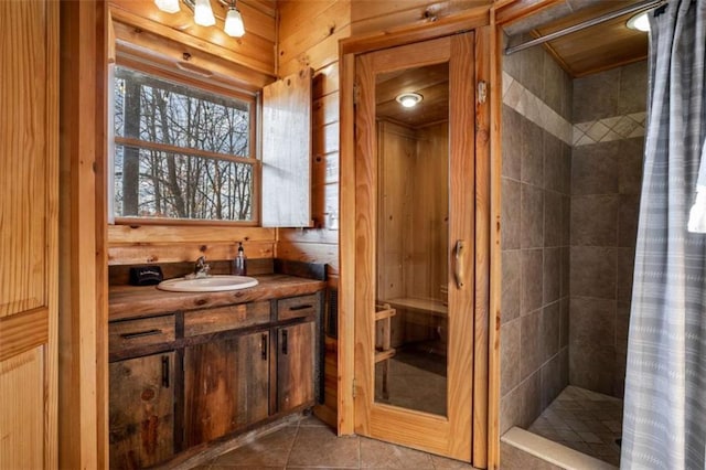 bathroom with tile patterned flooring, vanity, curtained shower, and wooden walls