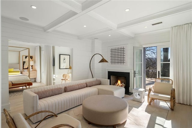 living room with beam ceiling, light wood-type flooring, coffered ceiling, and ornamental molding