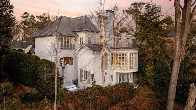 property exterior at dusk featuring a balcony