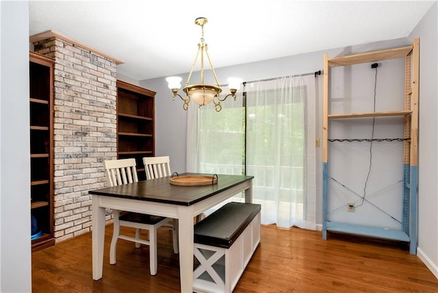 unfurnished dining area featuring a chandelier and wood finished floors