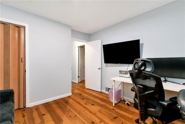 office space with light wood-style flooring and baseboards