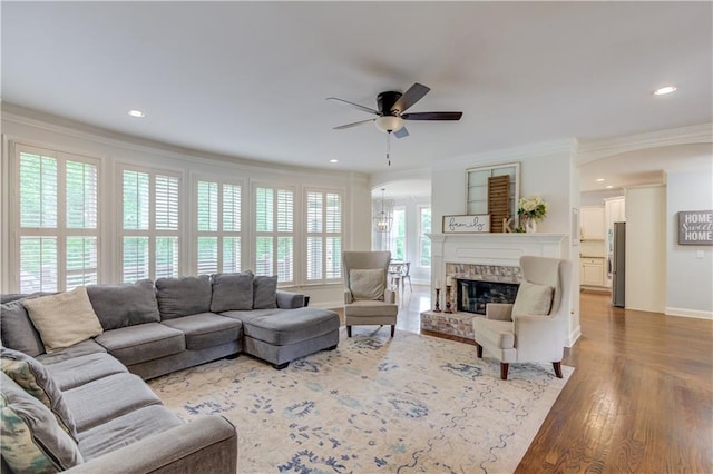 living room with light hardwood / wood-style floors, ceiling fan, a healthy amount of sunlight, and ornamental molding