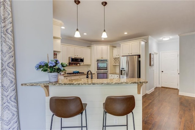 kitchen with dark hardwood / wood-style flooring, decorative light fixtures, appliances with stainless steel finishes, light stone counters, and ornamental molding