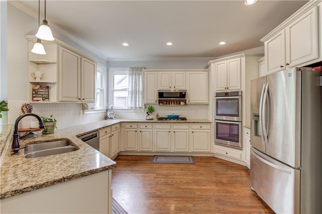 kitchen featuring pendant lighting, sink, appliances with stainless steel finishes, wood-type flooring, and tasteful backsplash