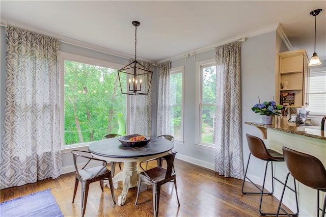 dining space with crown molding, a healthy amount of sunlight, a notable chandelier, and wood-type flooring