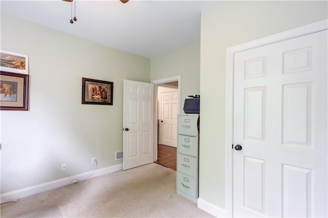 unfurnished bedroom with ceiling fan and light colored carpet