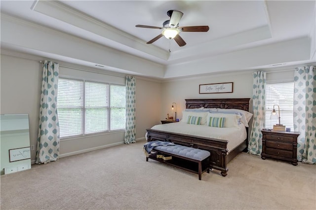 bedroom featuring ceiling fan, crown molding, light colored carpet, and a raised ceiling