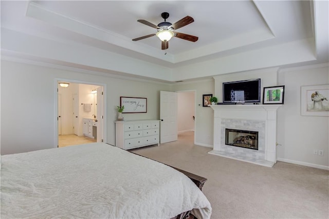 bedroom with a fireplace, light colored carpet, ceiling fan, and a raised ceiling