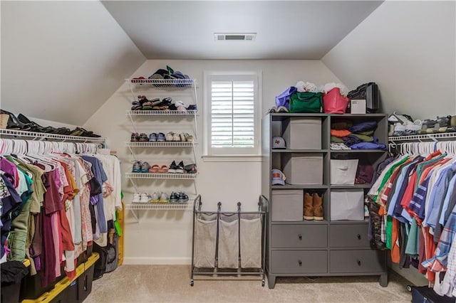 spacious closet featuring lofted ceiling and light colored carpet