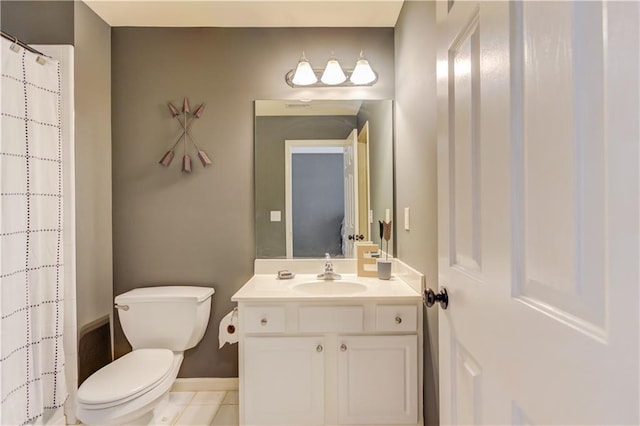 bathroom with tile floors, vanity with extensive cabinet space, and toilet