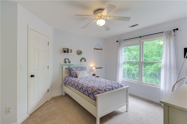 bedroom with light carpet, multiple windows, and ceiling fan