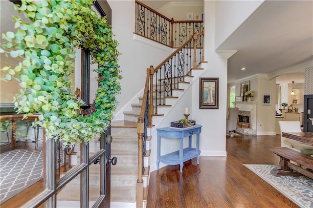 stairs with crown molding and dark hardwood / wood-style flooring