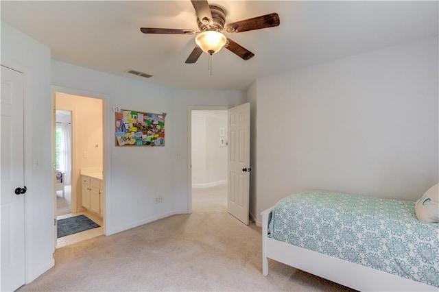 bedroom featuring light carpet, ceiling fan, and connected bathroom