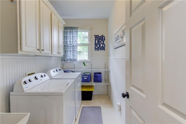 washroom with light tile floors, cabinets, sink, and washing machine and clothes dryer