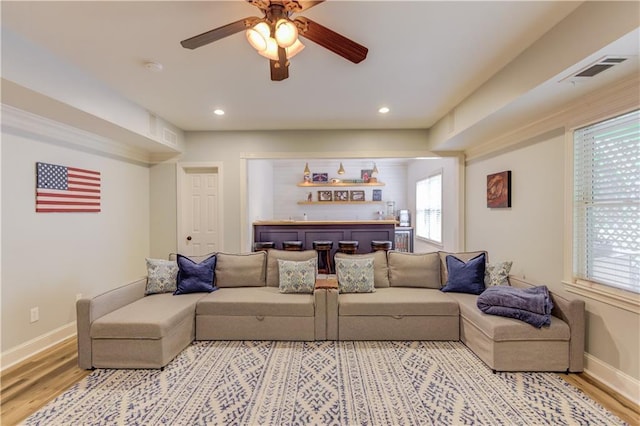 living room featuring ceiling fan, light hardwood / wood-style flooring, and a wealth of natural light