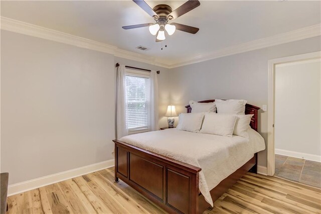 bedroom featuring ornamental molding, ceiling fan, and light wood-type flooring