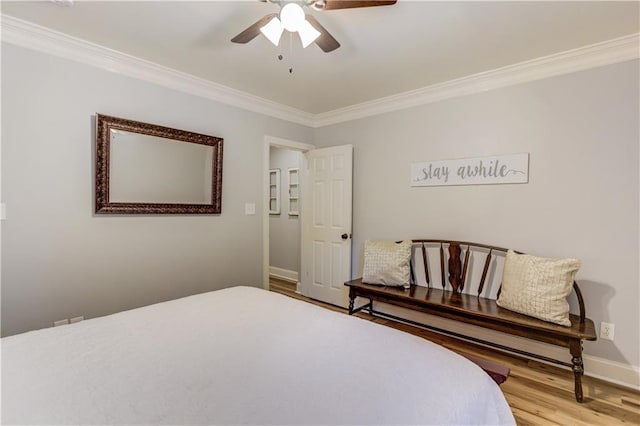 bedroom with ceiling fan, ornamental molding, and light wood-type flooring