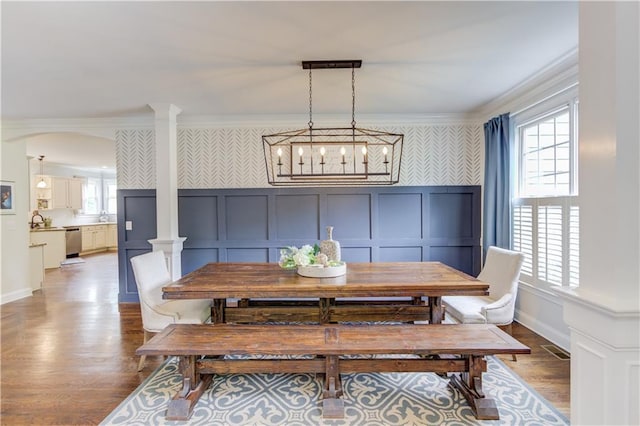 dining room with an inviting chandelier, crown molding, and hardwood / wood-style floors