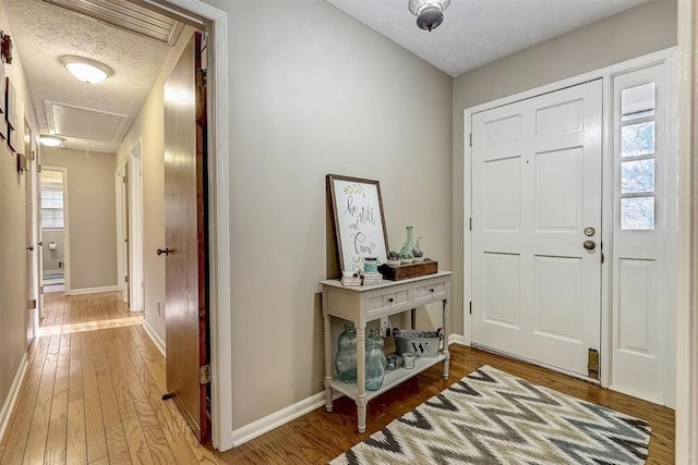 foyer entrance with wood-type flooring and a textured ceiling