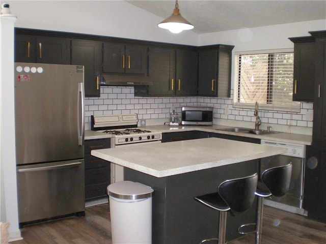 kitchen with vaulted ceiling, appliances with stainless steel finishes, hanging light fixtures, and dark wood-type flooring