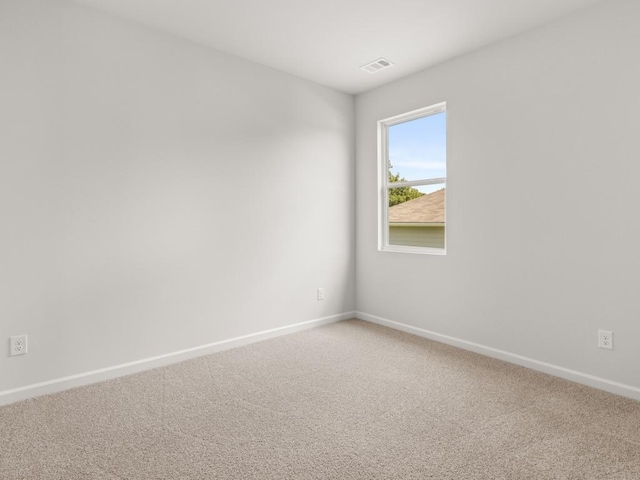 unfurnished room with baseboards and light carpet
