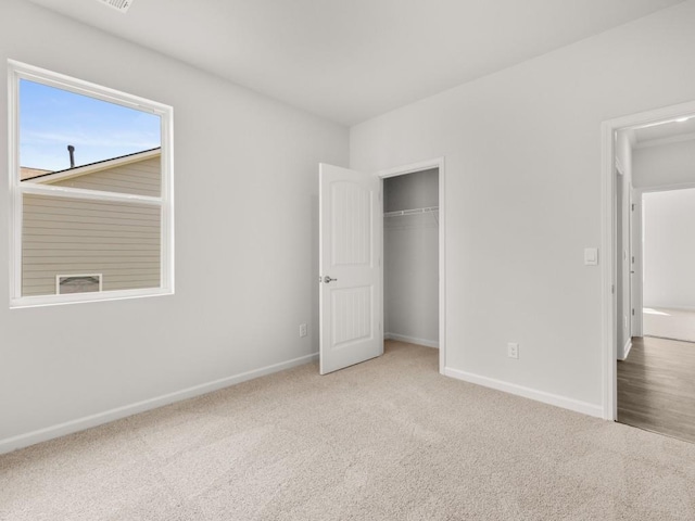unfurnished bedroom with carpet floors, baseboards, and a closet