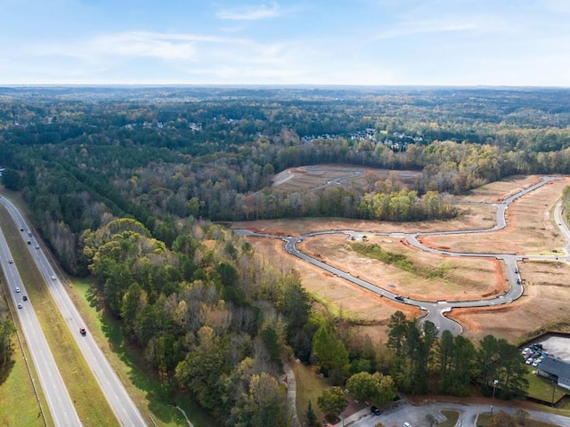 aerial view of property's location with a forest and a main thoroughfare