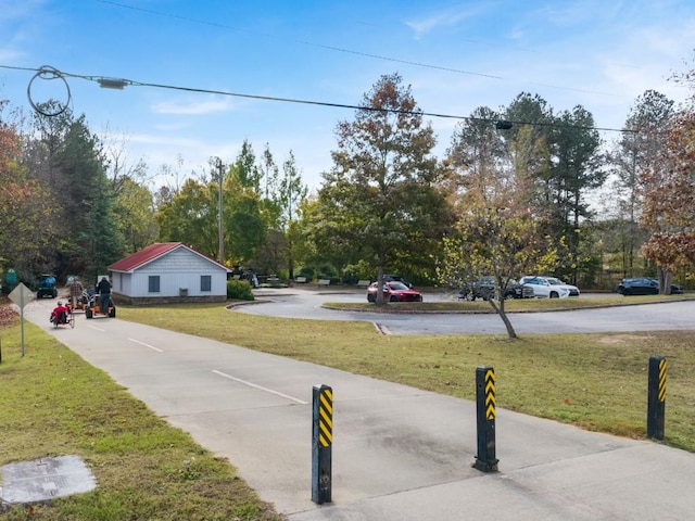view of concrete road featuring traffic signs and view of wooded area