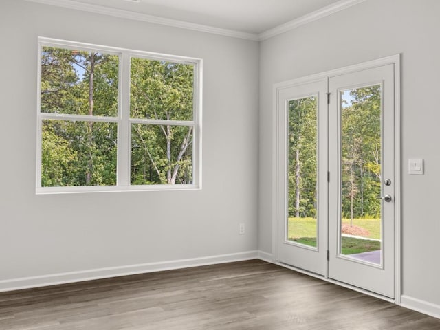 spare room with baseboards, wood finished floors, and ornamental molding