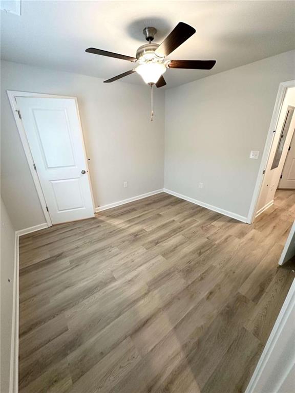 spare room with light wood-type flooring and ceiling fan