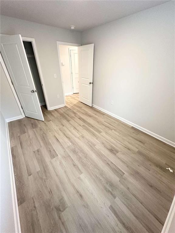 unfurnished bedroom with light hardwood / wood-style floors and a closet