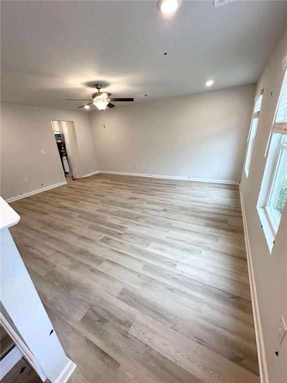 unfurnished living room featuring ceiling fan and light hardwood / wood-style floors