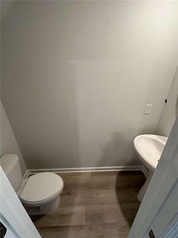 bathroom featuring toilet and wood-type flooring