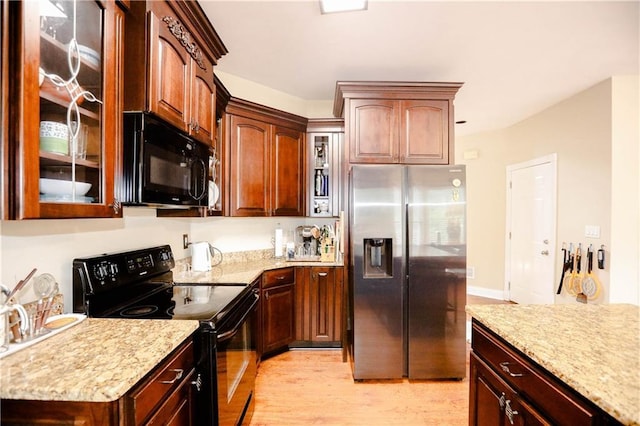 4000 Longlake Dr, Duluth, GA 30097 - kitchen featuring black appliances, light wood-style floors, glass insert cabinets, and light stone countertops