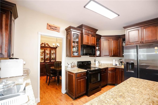 4000 Longlake Dr, Duluth, GA 30097 - kitchen featuring black appliances, light wood-style flooring, glass insert cabinets, light stone counters, and a chandelier