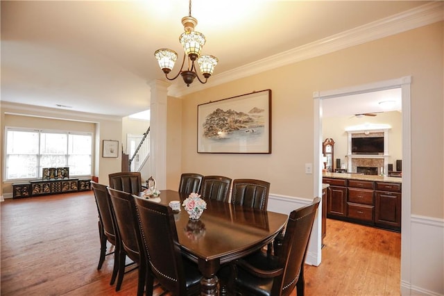 4000 Longlake Dr, Duluth, GA 30097 - dining area featuring light wood-style flooring, crown molding, a fireplace, stairway, and a chandelier