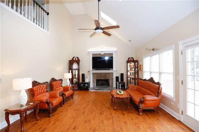 4000 Longlake Dr, Duluth, GA 30097 - living area with high vaulted ceiling, wood finished floors, a ceiling fan, a fireplace with raised hearth, and baseboards
