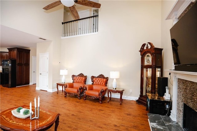 4000 Longlake Dr, Duluth, GA 30097 - living room with a premium fireplace, a towering ceiling, light wood finished floors, a ceiling fan, and baseboards