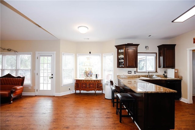 4000 Longlake Dr, Duluth, GA 30097 - kitchen featuring a breakfast bar area, dark brown cabinets, light stone countertops, and dark wood-style flooring
