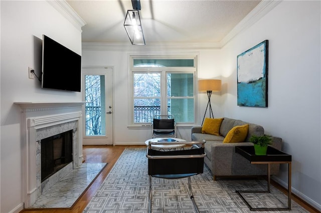 living area featuring baseboards, dark wood finished floors, a high end fireplace, and crown molding