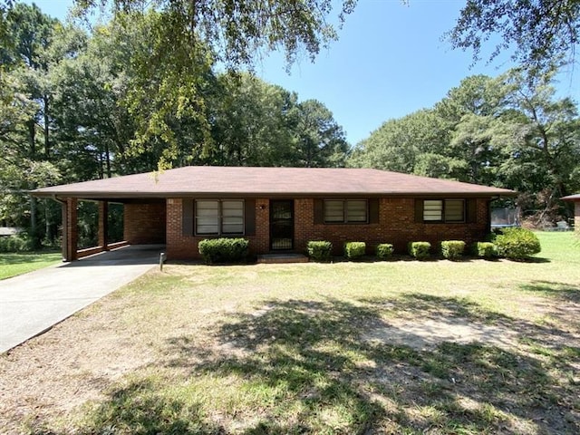 ranch-style house featuring a carport, concrete driveway, brick siding, and a front lawn