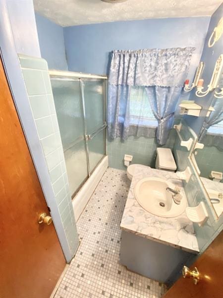 full bathroom with tile patterned flooring, a shower stall, toilet, and a textured ceiling