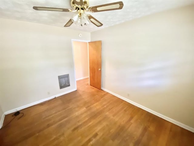 unfurnished room featuring a ceiling fan, baseboards, and wood finished floors