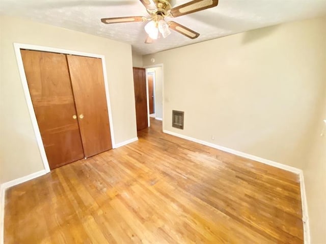 unfurnished bedroom with a closet, visible vents, light wood-style floors, a ceiling fan, and baseboards