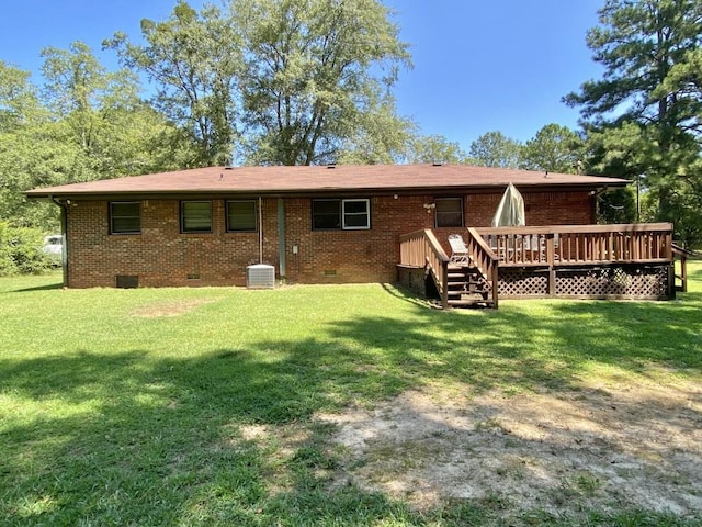 rear view of property featuring crawl space, a deck, a yard, central AC, and brick siding