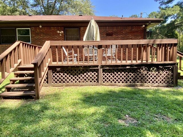 wooden terrace with stairway and a lawn