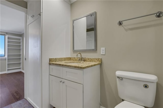 bathroom with toilet, hardwood / wood-style floors, and vanity