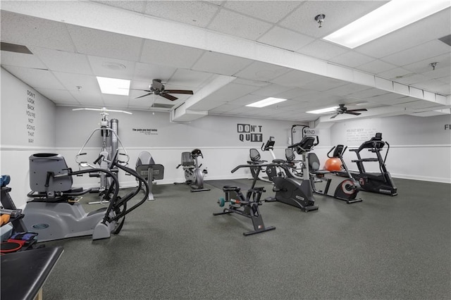 exercise room with ceiling fan and a paneled ceiling