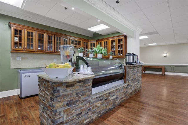 kitchen featuring dark wood-type flooring, ornamental molding, and fridge