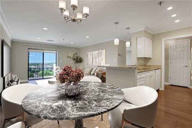 kitchen featuring hardwood / wood-style flooring, crown molding, white cabinetry, and light stone countertops